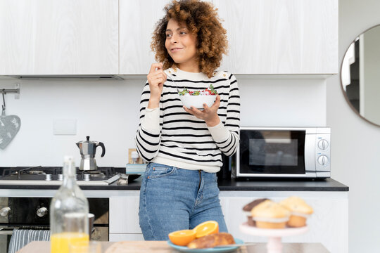 Woman eating strawberries at home