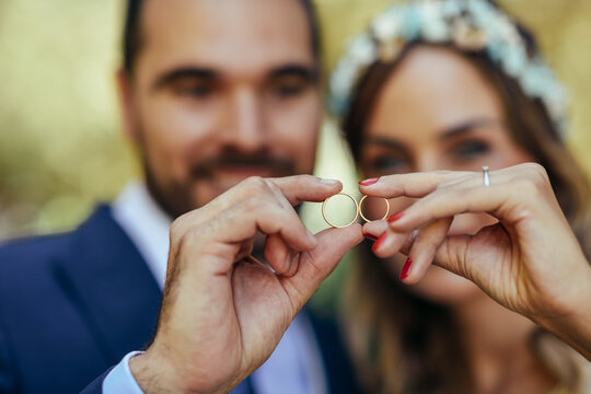 Happy bridal couple showing their wedding rings, close-up