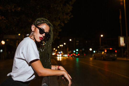 Cool young woman on a steet at night in the city