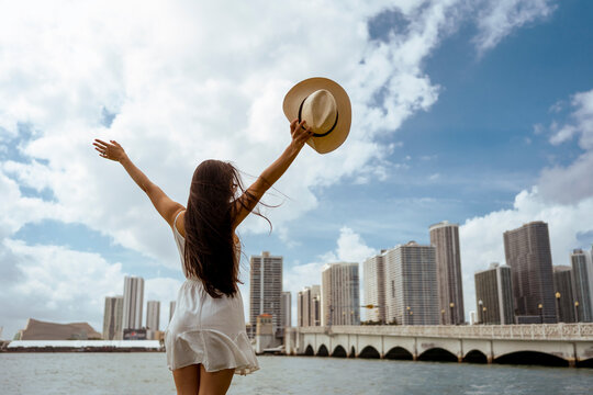 Young woman with arms outstretched standing in city