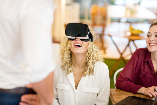 Blond woman trying out VR goggles at a workshop