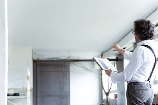 Architect with sketch book at construction site