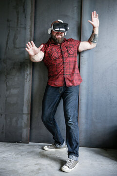 Excited bearded man wearing VR glasses