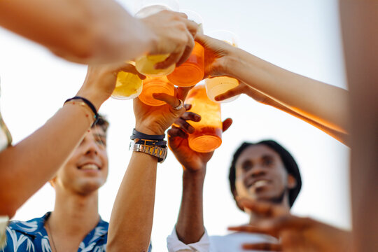 Happy multi-ethnic friends toasting drinks