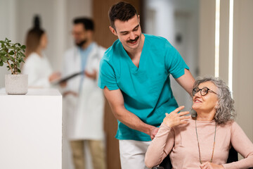 Fototapeta premium Caregiver assisting senior woman in wheelchair at hospital