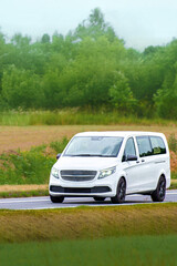 Delivery vehicle driving through green rural landscape
