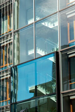 Modern urban architecture with a blue glass building facade showing windows pattern and corporate mood designed as a clean background with ample copy space