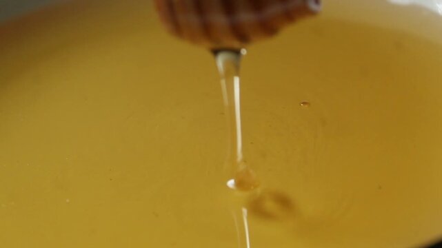 honey dripping from a wooden dipper