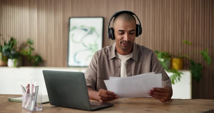 Smile, man and laptop with headphones in office for streaming podcast, proofreading and research. Happy, person and listening to music with pc, manuscript document and editing article for submission