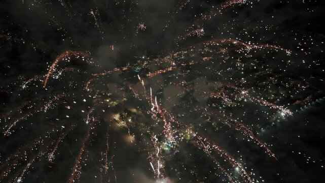 Aerial drone view of colorful fireworks exploding in the night sky during celebration