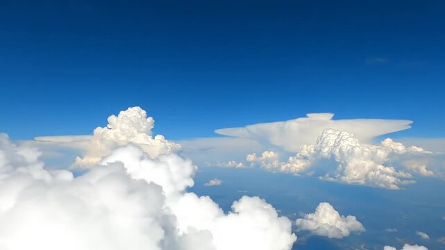 Bright blue sky with white fluffy cumulus clouds from above
