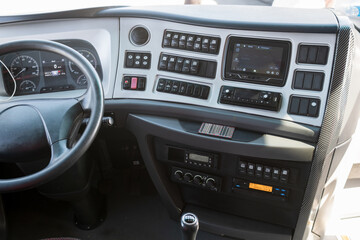 Obraz premium Interior view of a modern truck cabin featuring dashboard controls, steering wheel, and digital display for navigation and entertainment systems