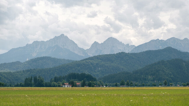 Alpine Foothills near Fuessen Bavaria Germany with Meadow Forested Hills and Mountains Film Look Muted Colors
