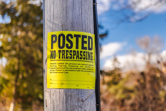 Private property no trespassing notice attached to utility pole outdoors