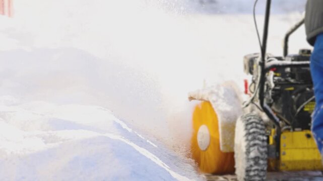 Removing snow with portable blower machine during winter, worker with gas snow blower removal in the streets after snowfall, clearing residential sidewalk driveway with snow sweeper, snowplow machine