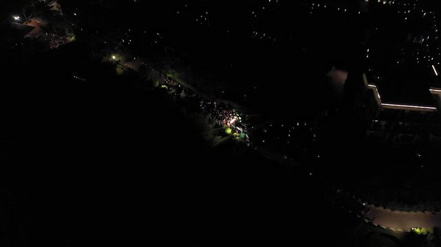 Aerial night shot of a traditional Indian wedding baraat with decorated car, dancers, and festive lights in india