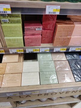 Saujon, France - January 24, 2026: Intermarche. Colorful soap bars displayed on wooden shelves in a retail store, featuring various scents and packaging designs