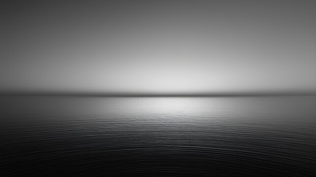 静かな海面のモノクロ風景。背景素材やデザイン用の抽象的なイメージ。
