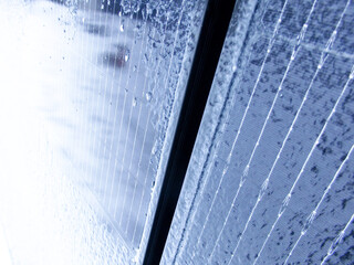 Extreme close-up of ice and frost patterns on a blue solar panel in winter.
