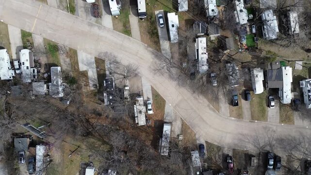 RV rows curve with pads arranged along interior loop close to US 75 frontage, E Parker Rd. Soft winter light, pale rooftops, leafless trees, muted pavement tones, layered textures, Plano, Texas