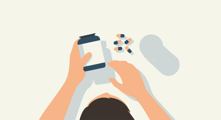 Overhead view of a person holding a smartphone and scattered pills on a flat surface