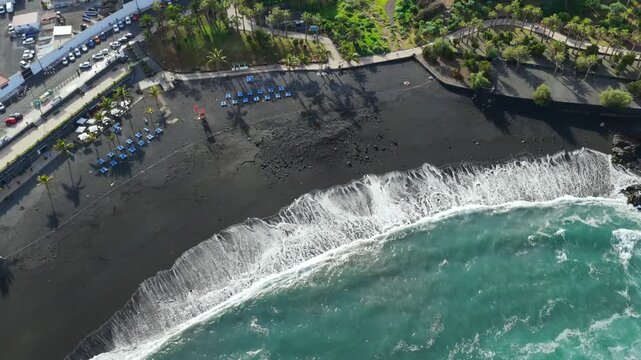Aerial of closed beach with red flags and warning signs due to E. coli contamination and sewage discharge in Tenerife