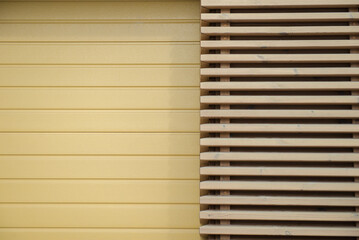 Modern facade detail with yellow wall and wooden slats