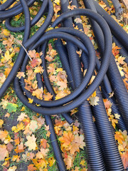 Black plastic pipes lie on the ground at project site