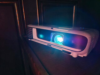 Movie is shown through projector. Light of blue color passes through lenses