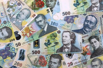 Fototapeta premium Romanian leu money bills pile on table. Romania banknotes of RON currency close up.