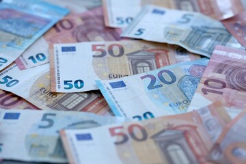 Obraz premium Euro money bills pile on table. Eurozone banknotes of EUR currency close up.