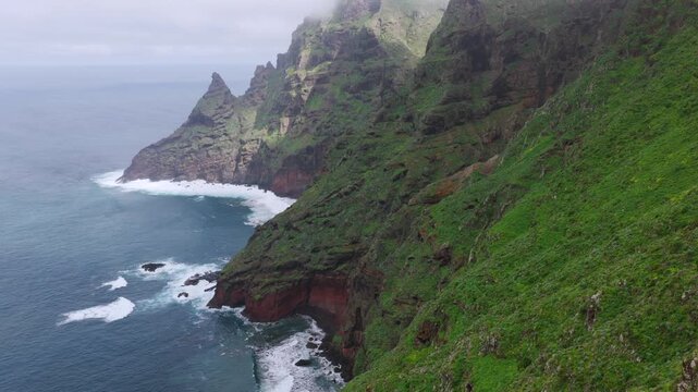 Aerial tracking shot over the rugged Anaga Massif peaks and the prehistoric barrancos of Punta del Hidalgo