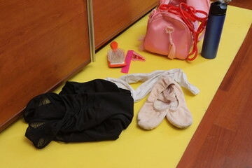 Ballet shoes, leotard, and accessories on training mat