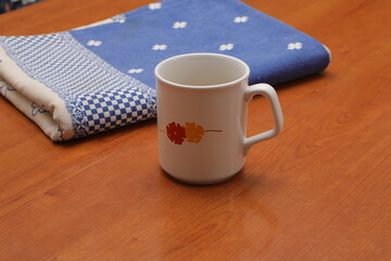 White ceramic mug with floral design on wooden table