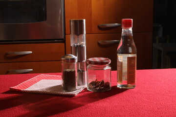Cooking spices and vinegar bottle on kitchen table