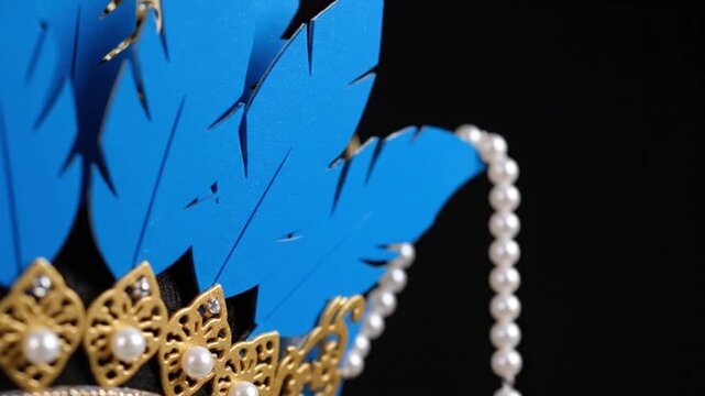 Close-up of Ornate Blue and Gold Traditional Headpiece with Pearls and Filigree Detail on Black Background