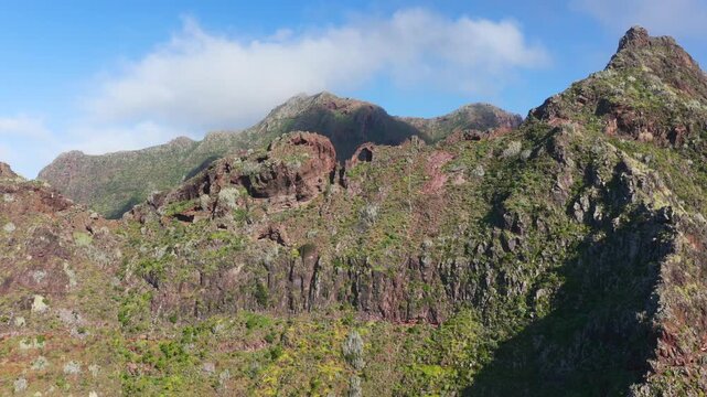 Aerial tracking shot over the rugged Anaga Massif peaks and the prehistoric barrancos of Punta del Hidalgo