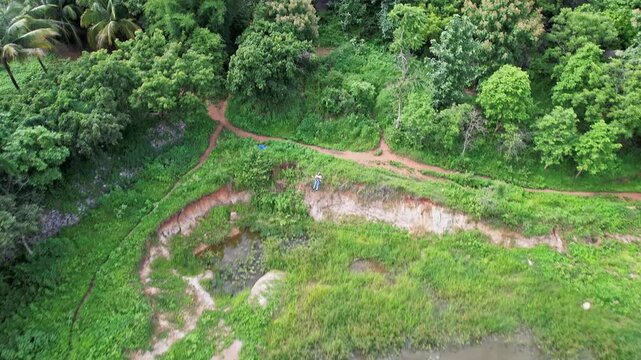 Tracking drone view of an adventurous girl zip-lining amidst the lush green hills of Ramanagara