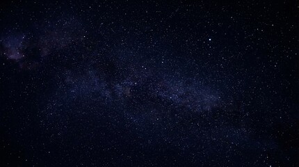 Fototapeta premium Dark night sky filled with distant stars and faint Milky Way band, deep space atmosphere, minimal low-light astrophotography style.