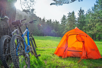 camping with tent and bicycles near mountains in summer