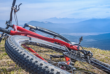 Mountain bike lying on grass with scenic mountain view