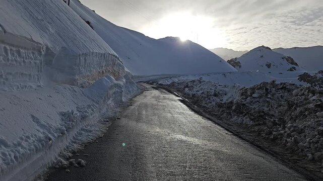Mountain pass road bordered by a tall snowbank on one side, set beneath a cloudy winter sky and surrounded by rugged, icy terrain.
📍Hawraman Takht, Kurdistan 