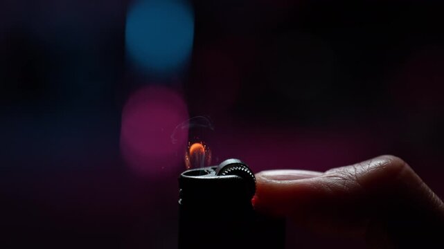 Flicking a Lighter with a Thumb in Macro and Slow Motion, Sparks Ignite the Gas Generating Flame Dancing on a Purple Background