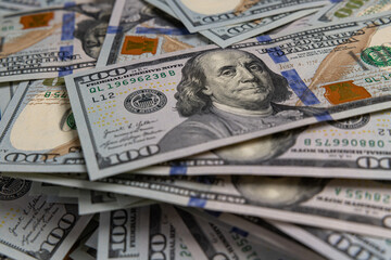 Background of Scattered One Hundred US Dollar Bills Representing Wealth and Finance