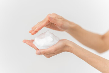 スキンケアプロセス。洗顔フォームの泡を手にのせている手元。