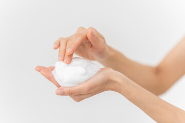 スキンケアプロセス。洗顔フォームの泡を手にのせている手元。
