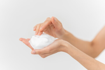 スキンケアプロセス。洗顔フォームの泡を手にのせている手元。