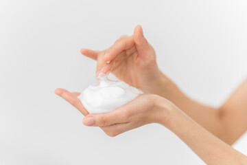 スキンケアプロセス。洗顔フォームの泡を手にのせている手元。