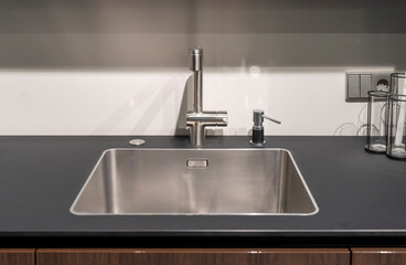 Modern steel kitchen sink with faucet and soap dispenser