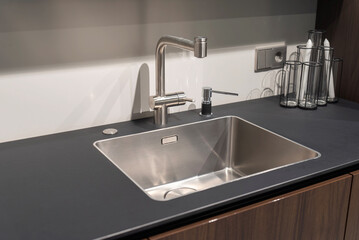 Modern steel kitchen sink with matte faucet and soap dispenser